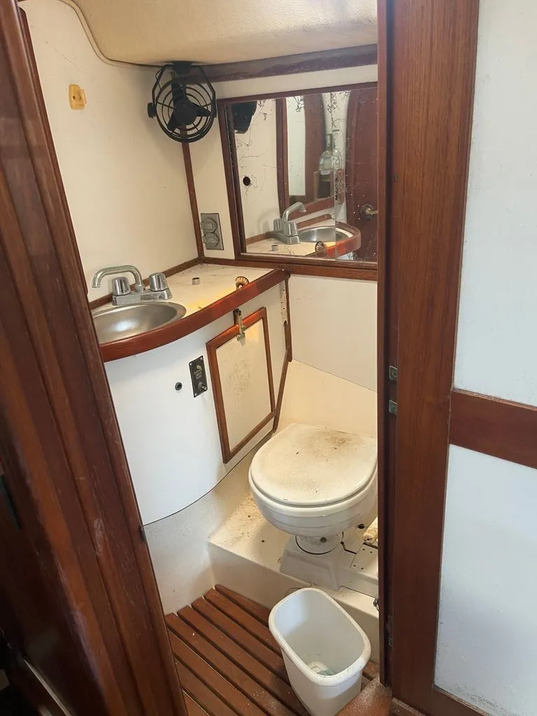 Slide: The Image of The image shows a boat bathroom with wood paneling, a sink, and a toilet. - 8