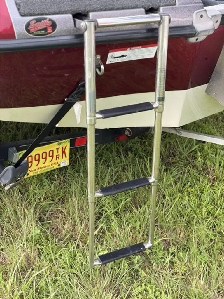 Slide: The Image of A retractable swim ladder is attached to the stern of a boat, resting on grass. - 19