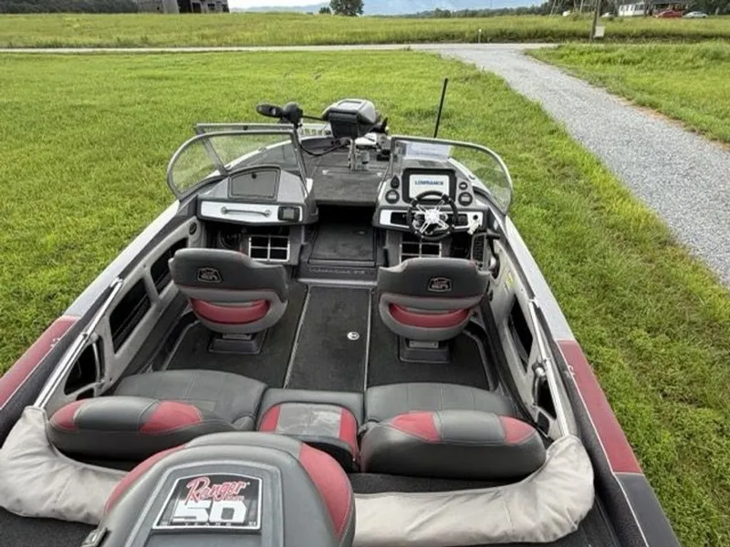 Slide: The Image of The image shows a 2012 Ranger 212LS Reata boat. It features four seats and a modern dashboard with electronics. - 16