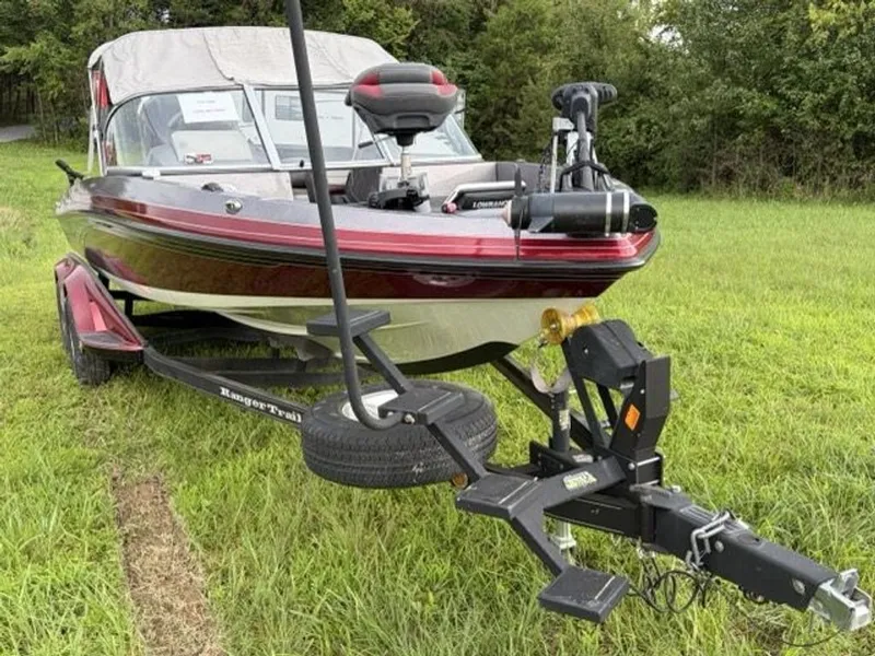 Slide: The Image of A 2012 Ranger 212LS Reata boat on a trailer in a grassy area. - 26