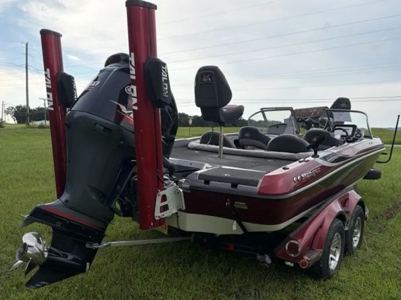 Slide: The Image of A red 2012 Ranger 212LS Reata boat on a trailer in a grassy field. - 21