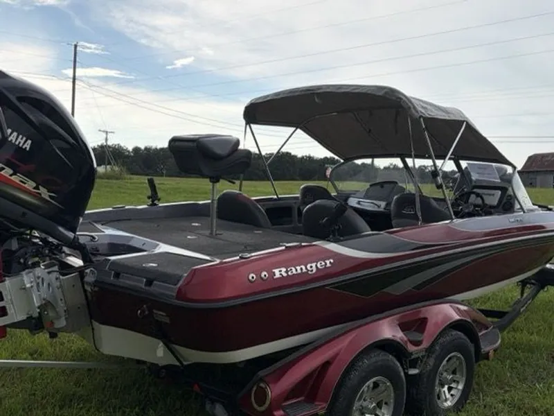 Slide: The Image of 2012 Ranger 212LS Reata with Yamaha outboard motor, parked on a trailer outdoors. - 22