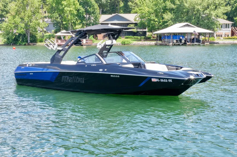 Slide: The Image of A black 2020 Malibu Wakesetter 24 MXZ boat on a calm lake. - 2