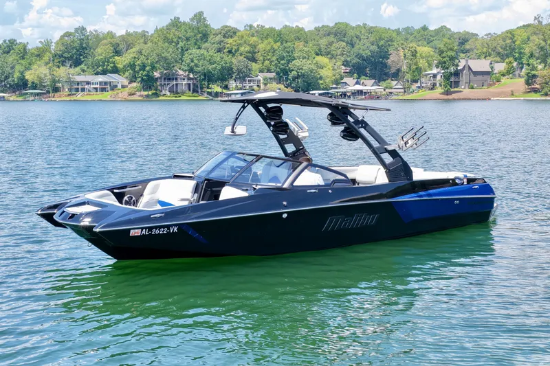Slide: The Image of 2020 Malibu Wakesetter 24 MXZ boat on a serene lake with lush shoreline. - 8
