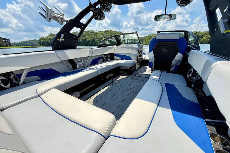 Slide: The Image of 2020 Malibu Wakesetter 24 MXZ interior with blue and white seating, lake view. - 14