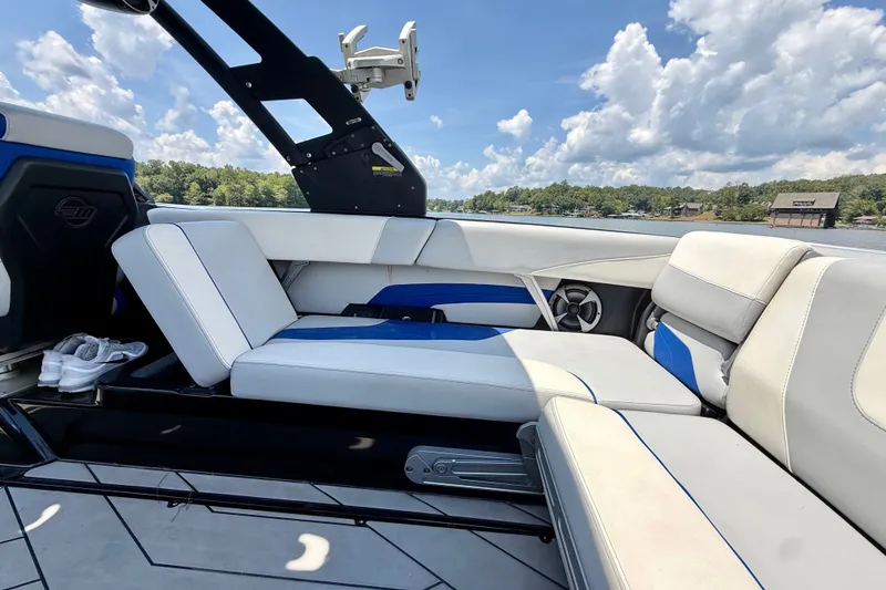 Slide: The Image of 2020 Malibu Wakesetter 24 MXZ interior with white and blue seating, lake view. - 16