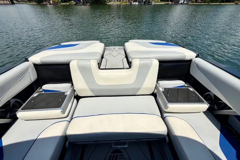 Slide: The Image of 2020 Malibu Wakesetter 24 MXZ boat interior with cushioned seating on a lake. - 32