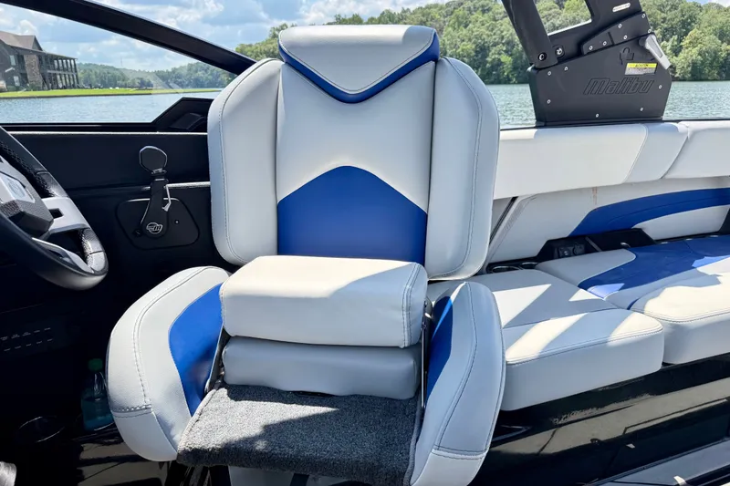Slide: The Image of 2020 Malibu Wakesetter 24 MXZ boat interior with blue and white seating. - 18