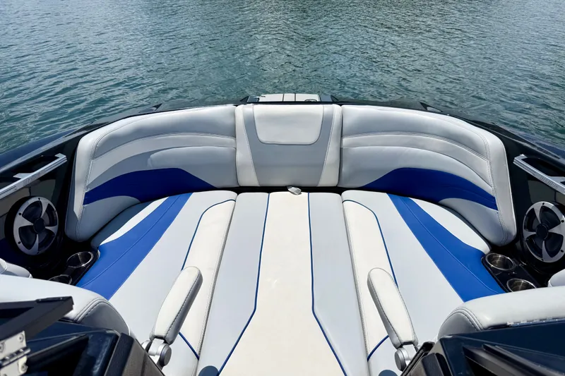 Slide: The Image of 2020 Malibu Wakesetter 24 MXZ boat interior with blue and white seating on water. - 25