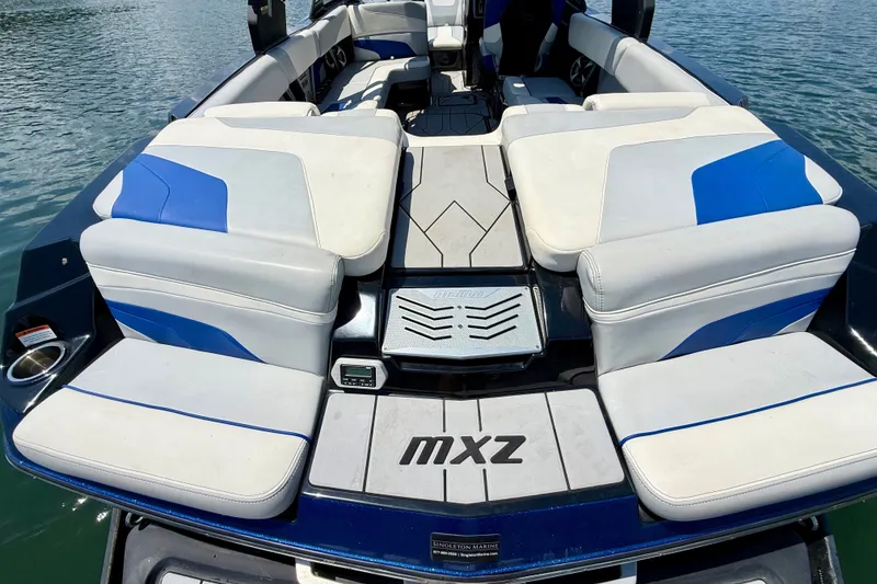 Slide: The Image of 2020 Malibu Wakesetter 24 MXZ boat interior with blue and white seating on water. - 37