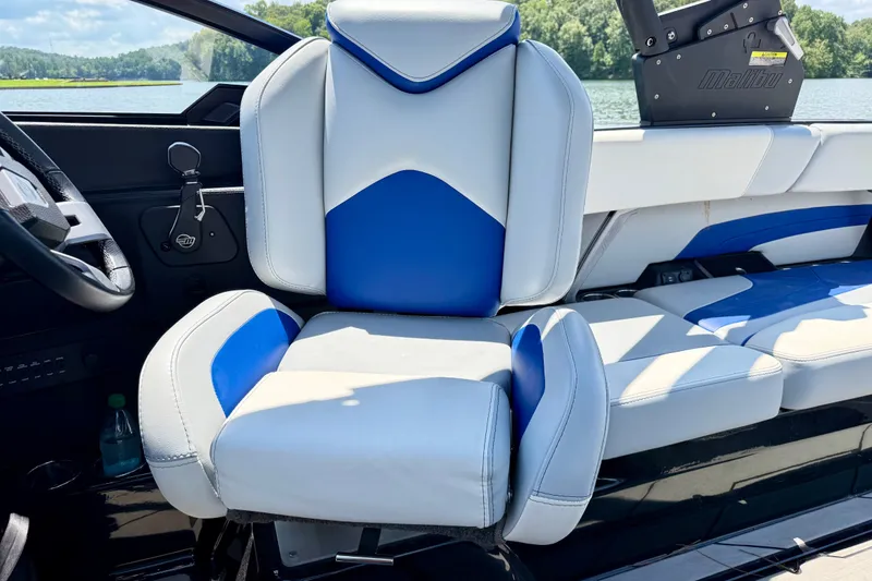 Slide: The Image of 2020 Malibu Wakesetter 24 MXZ boat interior with blue and white seating. - 17