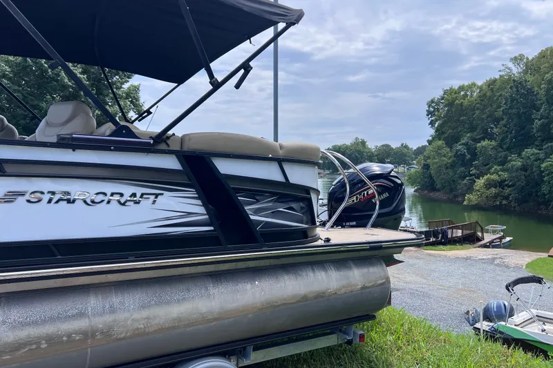Slide: The Image of 2024 Starcraft SLS 3 pontoon boat by a scenic lake with Yamaha engine. - 3