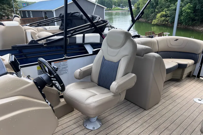 Slide: The Image of 2024 Starcraft SLS 3 boat interior with luxurious seating and steering wheel, docked by a lake. - 6