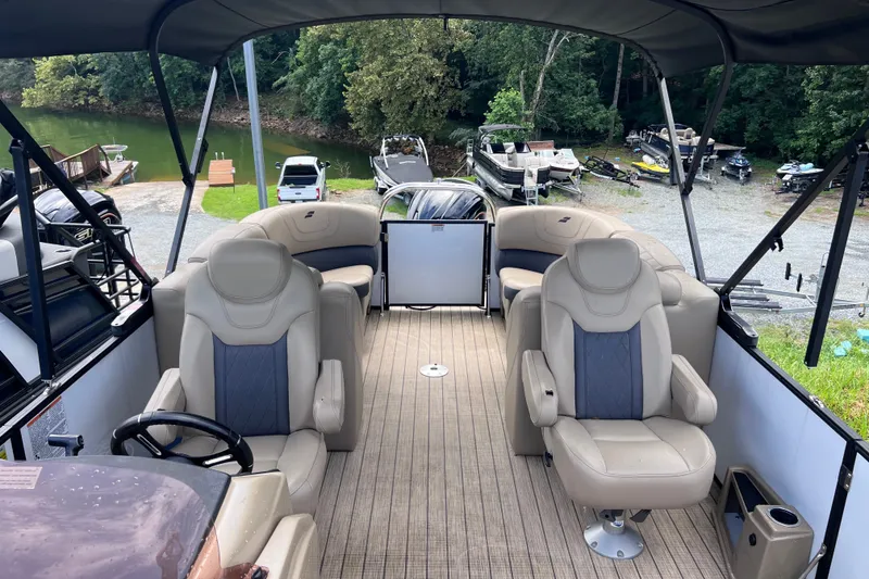 Slide: The Image of 2024 Starcraft SLS 3 pontoon boat interior with plush seating and scenic lake view. - 7