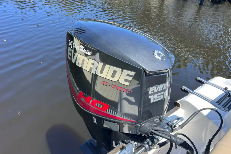 Slide: The Image of Evinrude outboard motor on 2016 Key West 203 FS boat, docked on calm water. - 43