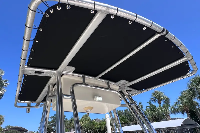 Slide: The Image of 2016 Key West 203 FS boat T-top against clear blue sky and palm trees. - 24