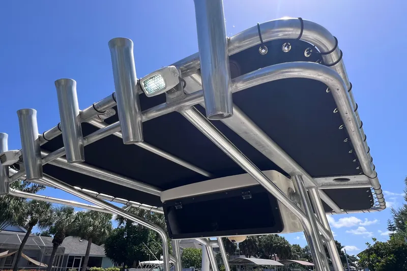 Slide: The Image of T-top of a 2016 Key West 203 FS boat with rod holders under a clear sky. - 23