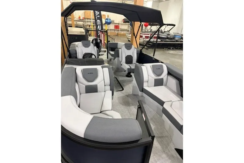 Slide: The Image of 2027 Alera M21Q boat interior with modern seating and canopy in showroom. - 18