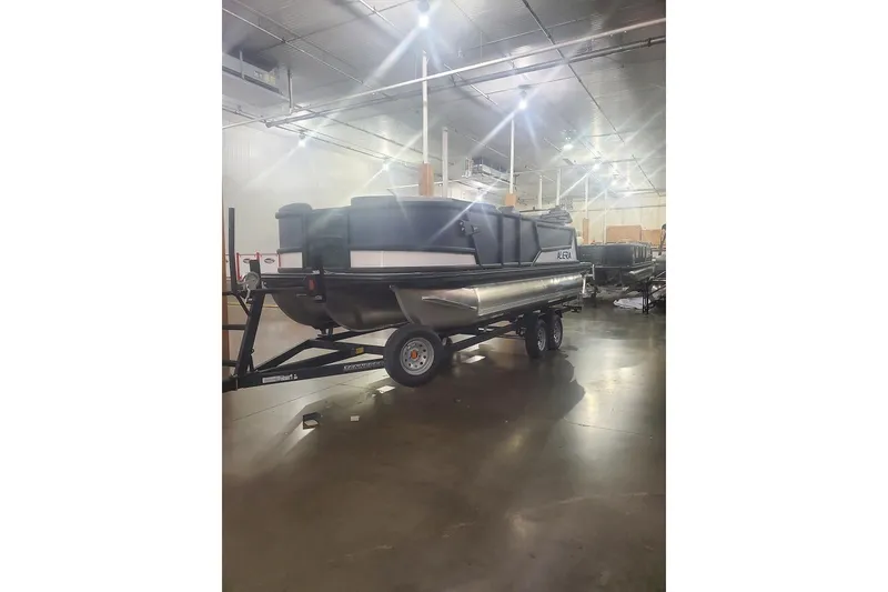 The Image of 2027 Alera M21Q pontoon boat on trailer in warehouse setting. - 0