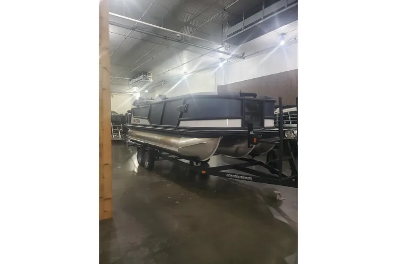Slide: The Image of 2027 Alera M21Q pontoon boat on trailer in indoor storage facility. - 1