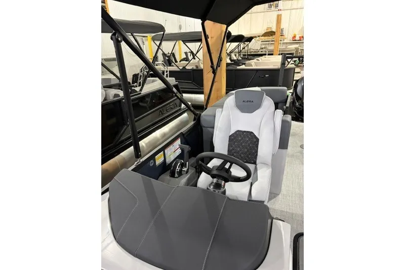 Slide: The Image of 2027 Alera M21Q boat interior with steering wheel and cushioned seating. - 15