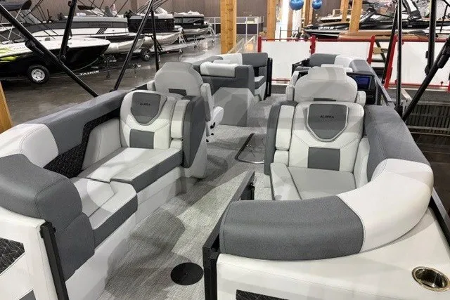 Slide: The Image of 2027 Alera M21Q boat interior with gray and white seating, displayed in a showroom. - 20
