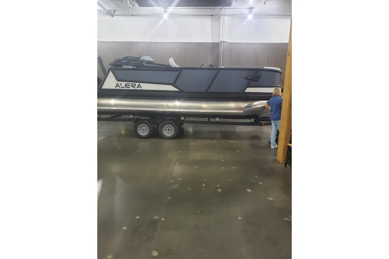 Slide: The Image of Alera M21Q 2027 pontoon boat on trailer in indoor setting. - 6
