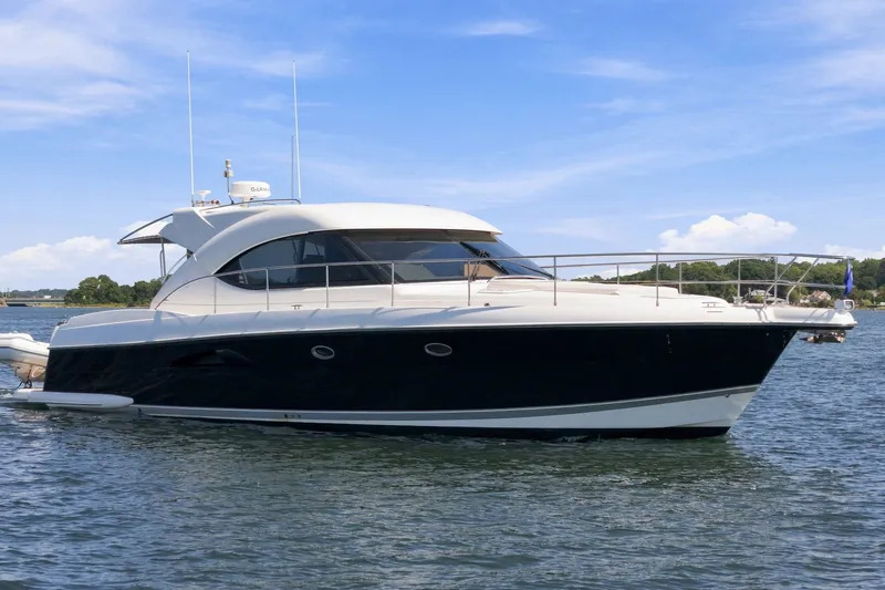 Slide: The Image of 2009 Riviera 4700 Sport Yacht cruising on a sunny day, showcasing sleek design and elegance. - 4