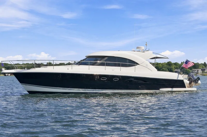 The Image of 2009 Riviera 4700 Sport Yacht cruising on a sunny day with an American flag. - 0