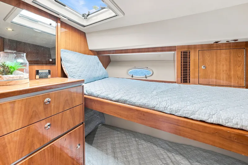 Slide: The Image of Luxurious 2009 Riviera 4700 Sport Yacht cabin with wooden cabinetry and cozy bedding. - 24