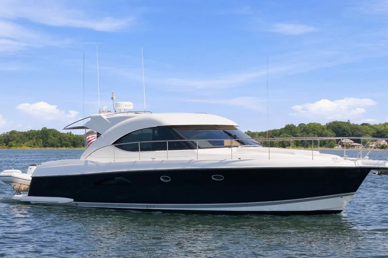 Slide: The Image of 2009 Riviera 4700 Sport Yacht on calm water under a clear blue sky. - 3