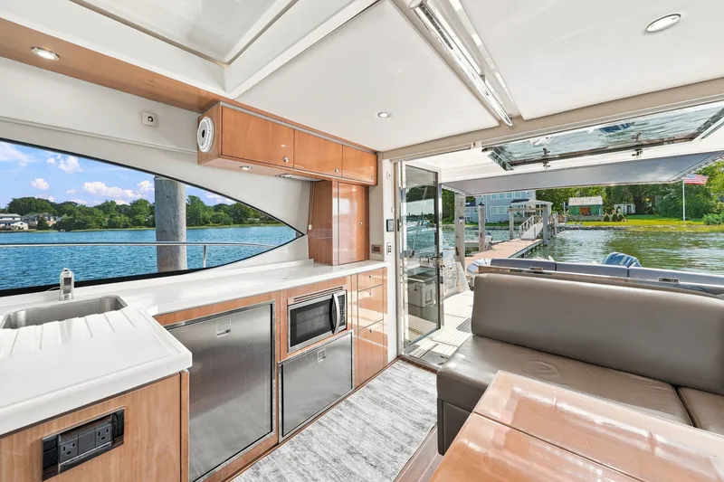 Slide: The Image of Luxurious 2009 Riviera 4700 Sport Yacht interior with modern kitchen and scenic water view. - 11