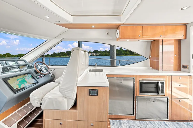 Slide: The Image of Interior of 2009 Riviera 4700 Sport Yacht with modern helm and kitchen amenities. - 14