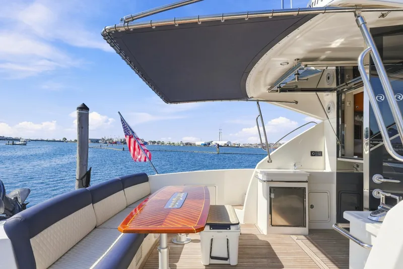 Slide: The Image of 2009 Riviera 4700 Sport Yacht deck with seating, table, and ocean view. - 7