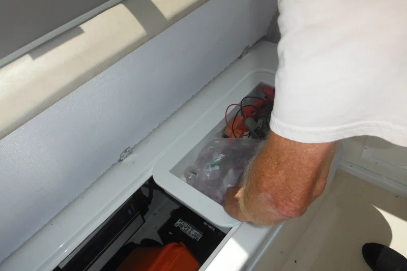 Slide: The Image of Man accessing storage compartment on 2020 Steiger Craft 255 Miami boat. - 34