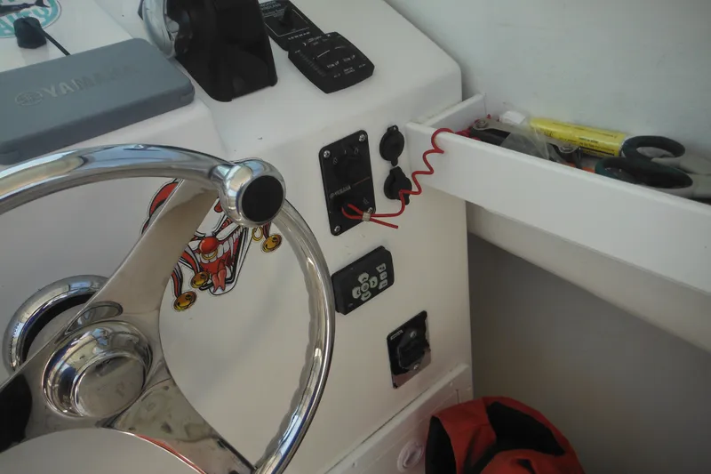 Slide: The Image of Steering wheel and controls of a 2020 Steiger Craft 255 Miami boat cockpit. - 49