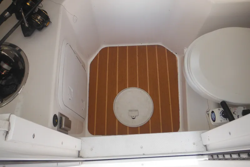 Slide: The Image of Interior of 2020 Steiger Craft 255 Miami boat with wooden flooring and marine toilet. - 14