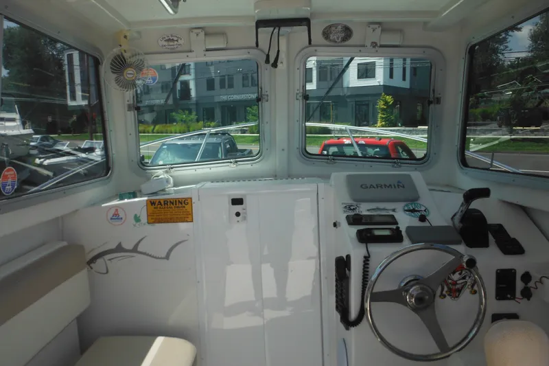 Slide: The Image of Interior view of 2020 Steiger Craft 255 Miami boat cockpit with steering wheel and navigation equipment. - 32
