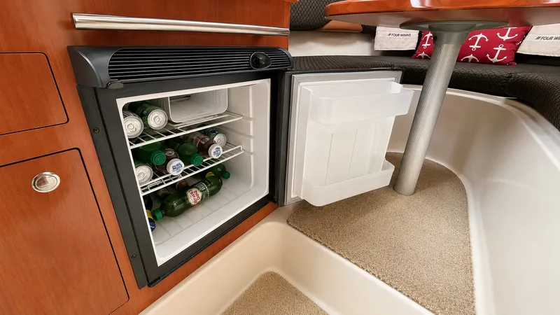 Slide: The Image of The interior of a 2006 Four Winns 278 Vista shows an open fridge stocked with drinks. - 9