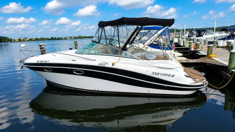 The Image of A white boat docked with a black canopy, under a clear blue sky. - 0
