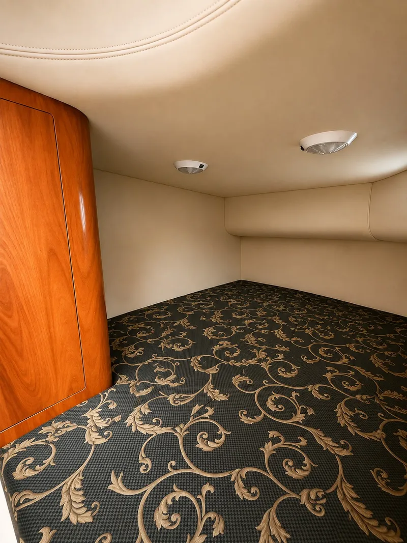 Slide: The Image of Interior of a 2006 Four Winns 278 Vista with patterned carpet and wood accents. - 11