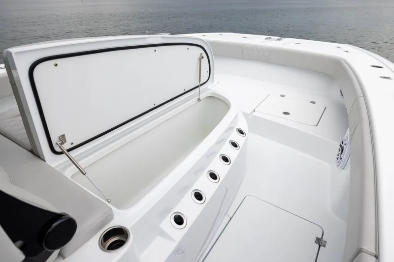 Slide: The Image of 2025 Freeman 35 boat interior with open storage compartment, sleek white design, and ocean backdrop. - 20