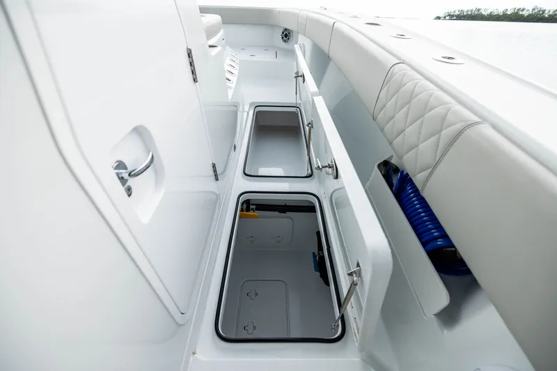 Slide: The Image of Freeman 35 boat storage compartments, 2025 model, featuring sleek white design and cushioned seating. - 38