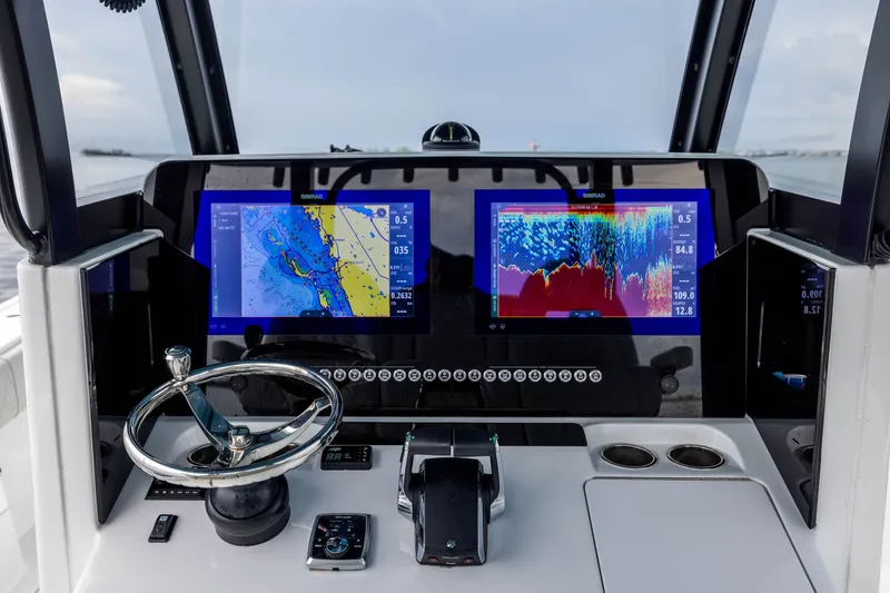 Slide: The Image of Modern Freeman 35 boat dashboard with dual navigation screens, steering wheel, and controls, 2025 model. - 31