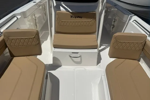Slide: The Image of 2026 Bayliner Trophy T22CX boat interior with tan cushioned seating and storage compartments. - 15