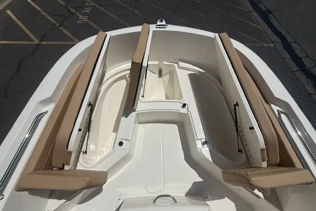 Slide: The Image of 2026 Bayliner Trophy T22CX boat interior with tan seating and storage compartments. - 14
