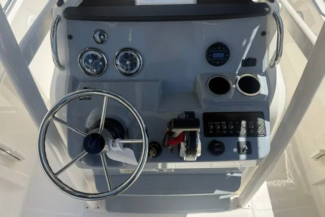 Slide: The Image of 2026 Bayliner Trophy T22CX boat dashboard with steering wheel and control panel. - 11