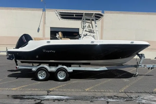 The Image of 2026 Bayliner Trophy T22CX boat on trailer, parked outdoors. - 0