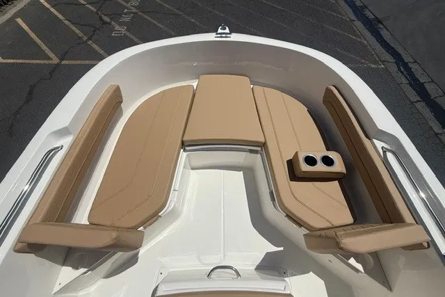 Slide: The Image of 2026 Bayliner Trophy T22CX boat interior with tan cushioned seating and cup holders. - 13