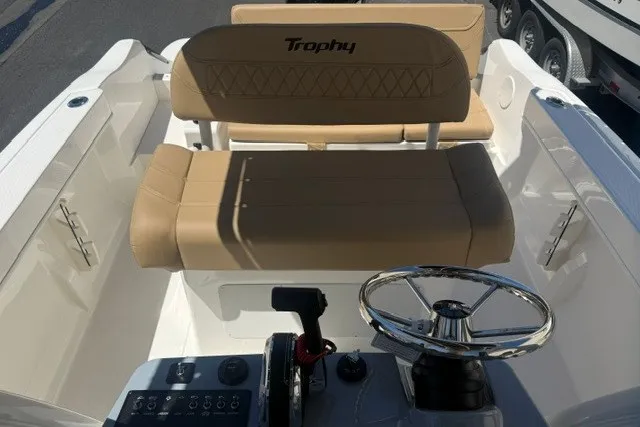 Slide: The Image of 2026 Bayliner Trophy T22CX boat interior with tan seating and steering wheel. - 16